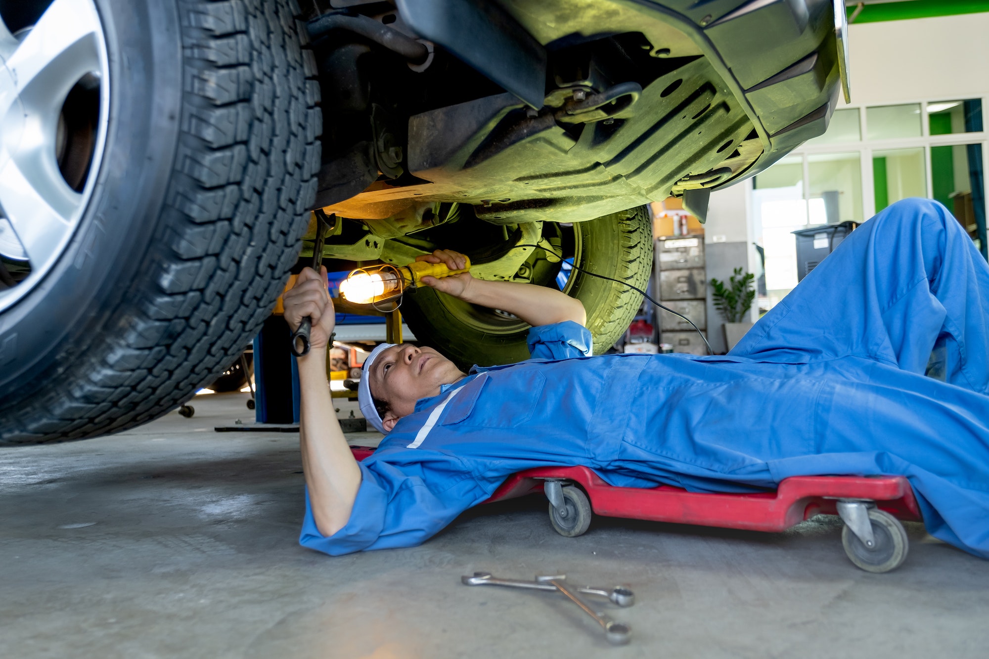 Rapid Fix technician performing an under-vehicle safety check and tyre service.