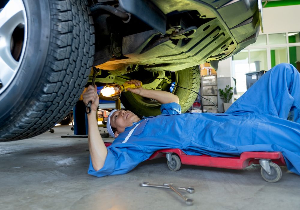 Rapid Fix technician performing an under-vehicle safety check and tyre service.